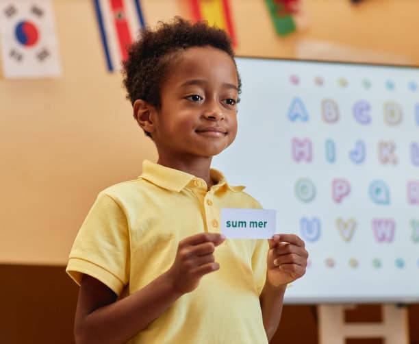 Boy Practicing Phonics With Word Card