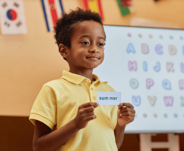 Boy Practicing Phonics With Word Card