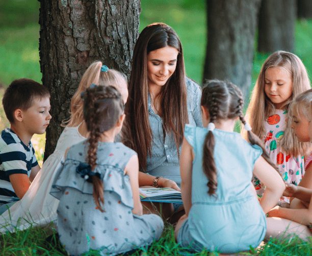 Child Laying In Grass With Book
