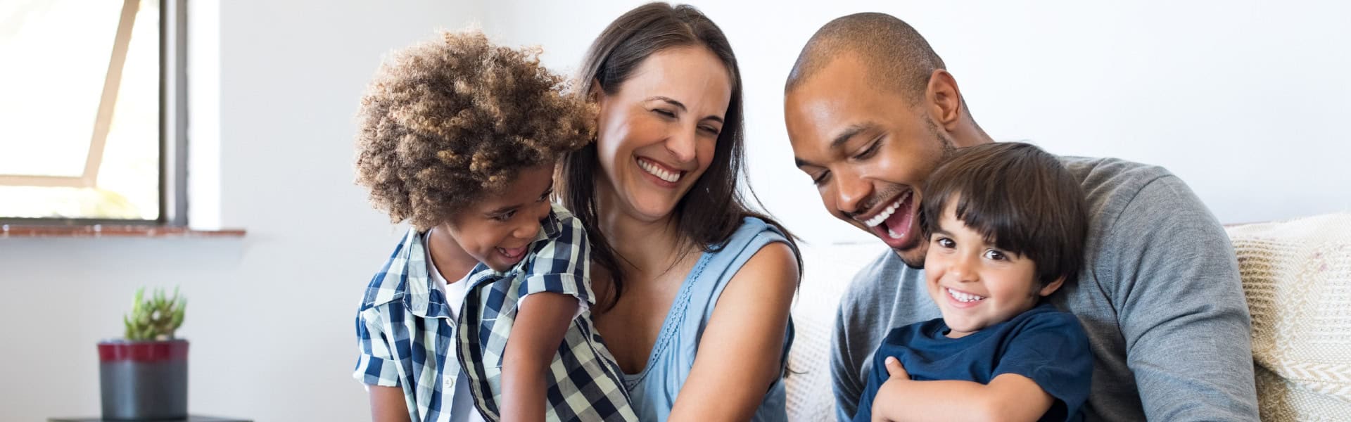 Happy Family Laughing Together On Couch