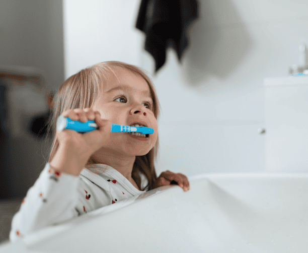 Toddler Brushing Own Hair During Routine