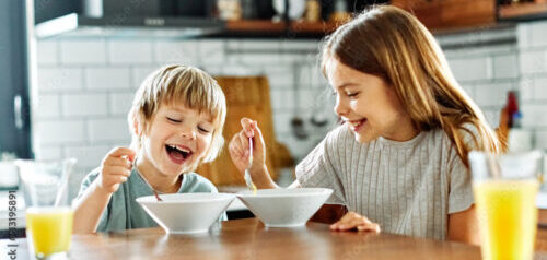 child girl boy eating kid brother sister food breakfast kitchen together morning childhood dessert sweet oatmeal meal cereals love family together fun happy