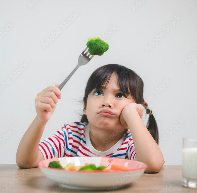 Nutrition & healthy eating habits for kids concept. Children do not like to eat vegetables. Little cute girl refuses to eat healthy vegetables.