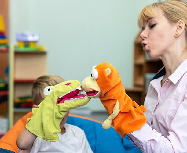 Educator Using Animal Hand Puppets For Child Language Development