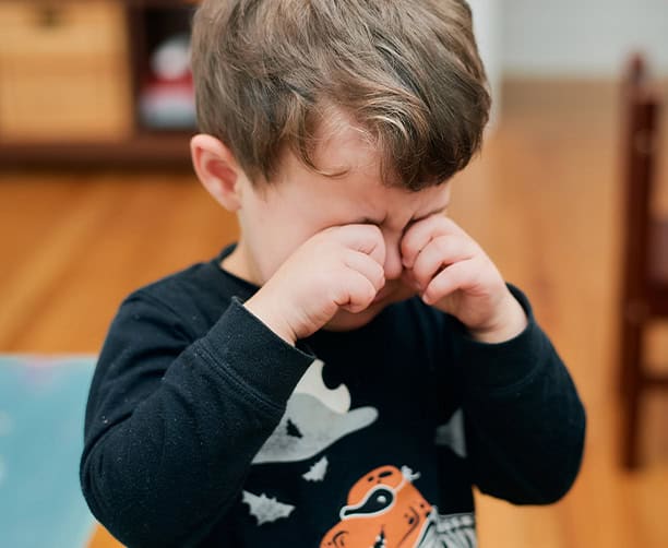 Young Child Rubbing Eyes During Emotional Moment